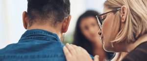 woman with supportive hand on mans shoulder