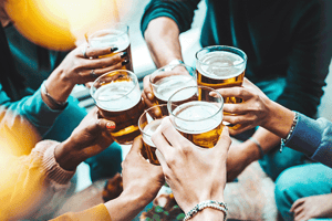 Groups of people raising glasses of drinks