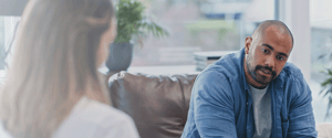man sitting on a sofa walking to a nurse