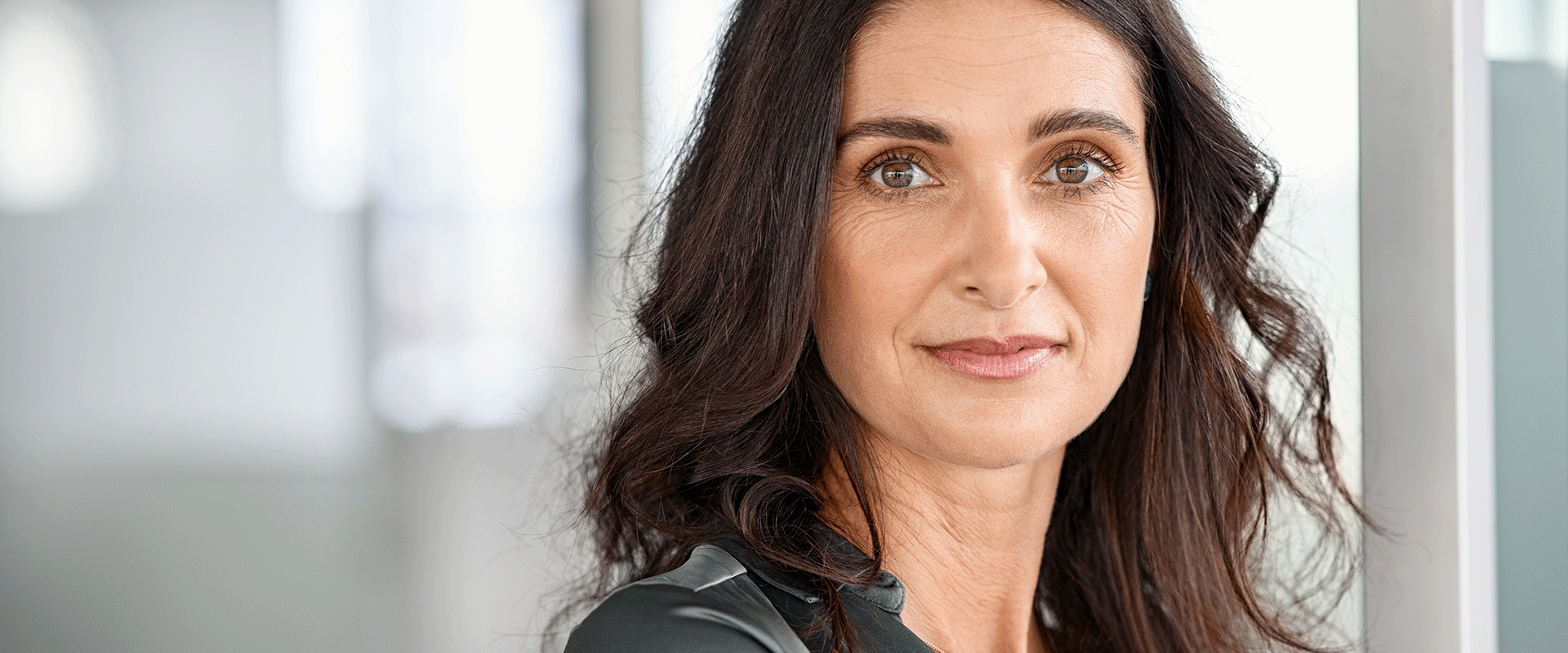 Portrait of woman with dark hair taken in an office