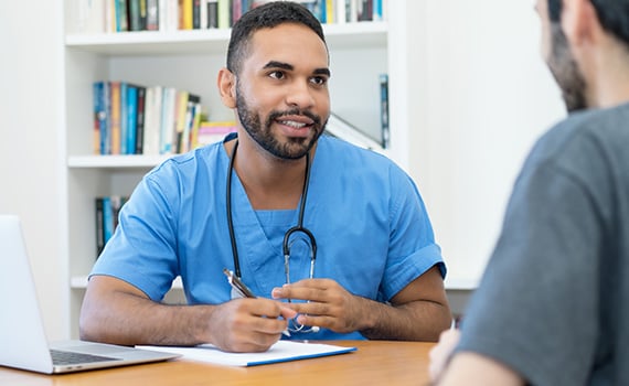 male nurse talking to male patient about in clinic scan
